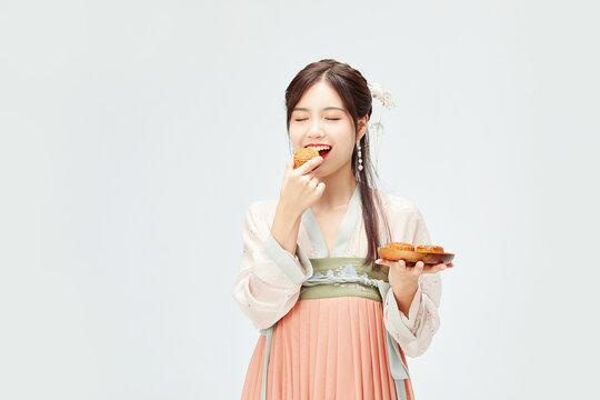 Young woman in hanfu eating mooncake