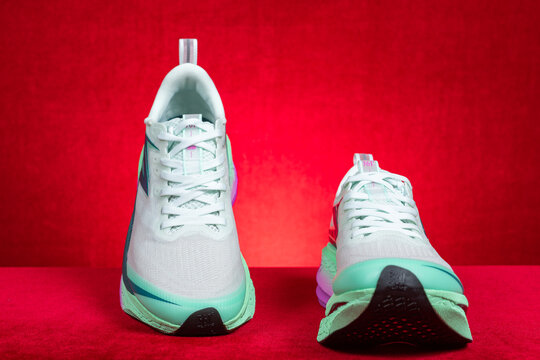 Zhongshan China-March 7 2026: 361 white and green running shoes for boy on red.