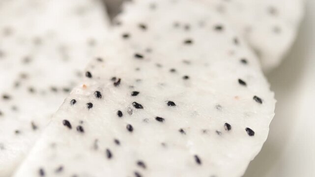 Pile of fresh sliced dragon fruit chunks slowly rotating on plate. Close-up shot