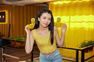 Young woman posing with skateboard indoors in casual urban style © TuBichHong