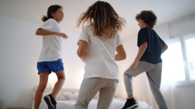 Three energetic children jumping and playing on a bed indoors