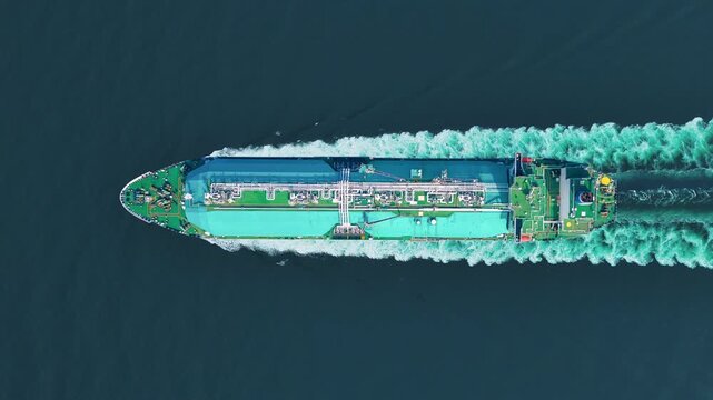 LNG tanker ship sailing in the open ocean. Liquefied Natural Gas carrier vessel with white spherical tanks transporting energy fuel. freight transportation shipping Global gas supply logistics.