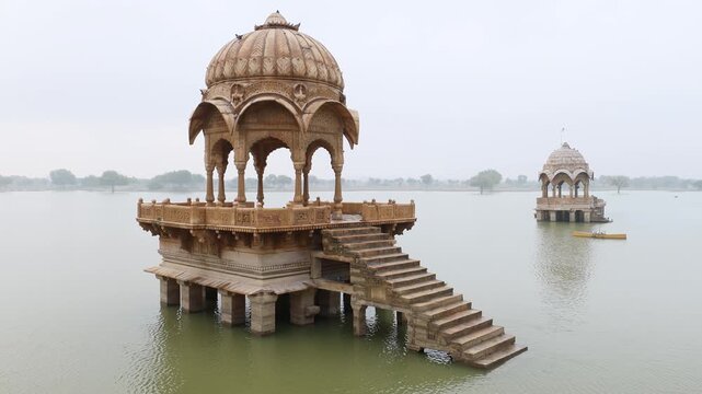 Ancient Indian cenotaphs stand majestically in a serene lake, reflecting history and architectural beauty.