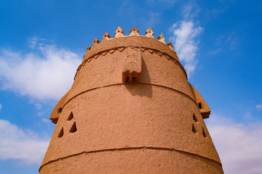 A traditional mud brick watchtower and defensive wall in the heritage village of Ushaiqer, Saudi Arabia