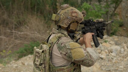 Fototapeta premium A special forces soldier aims his rifle during a tactical training exercise in a rugged outdoor environment, demonstrating precision and combat readiness.