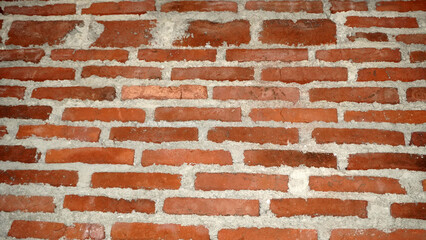 Naklejka premium Classic red brick wall with white mortar joints.