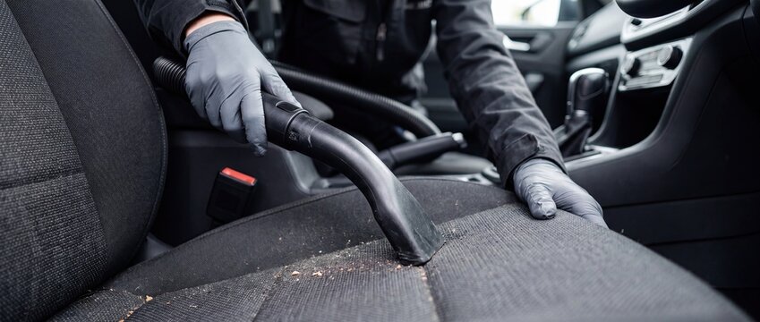 Car interior cleaning with vacuum on seat professional detailing