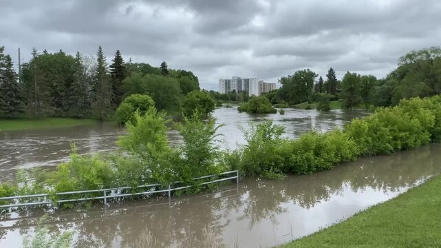 Winnipeg River Flooding After Heavy Rain.Flooded river and submerged park areas in Winnipeg, Manitoba, following intense rainfall. Storm clouds and high water levels highlight urban flood risk and ext