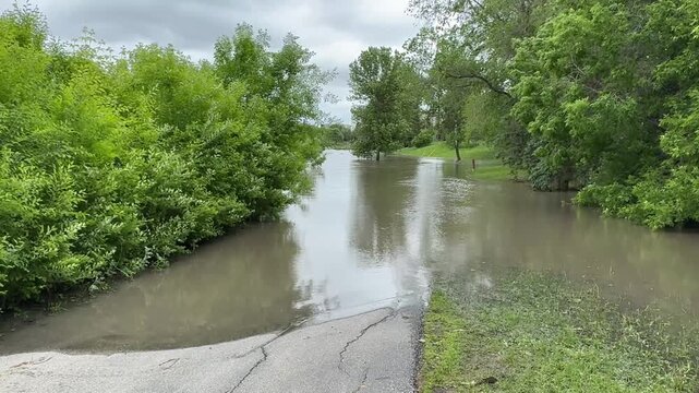 Winnipeg River Flooding After Heavy Rain.Flooded river and submerged park areas in Winnipeg, Manitoba, following intense rainfall. Storm clouds and high water levels highlight urban flood risk and ext