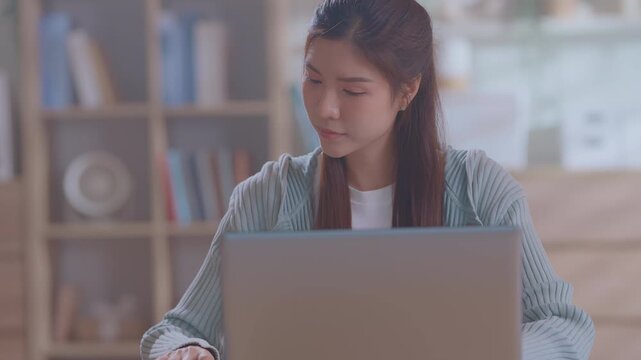 Smiling asian business woman using tablet laptop with equipment placed for doing finance on an home office desk, tax, report, accounting, statistics, and analytical research concept.
