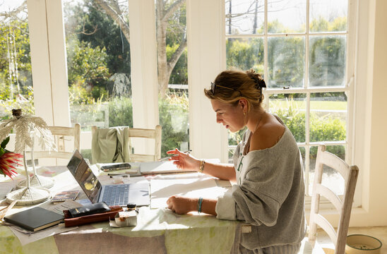 young woman artist doing watercolor drawing in her studio