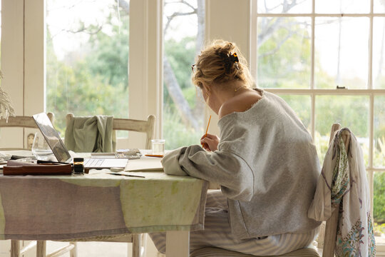 young woman artist doing watercolor drawing in her studio