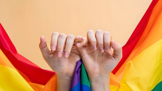 Hands Holding Rainbow Flag Symbolizing Unity and Acceptance in LGBTQ+