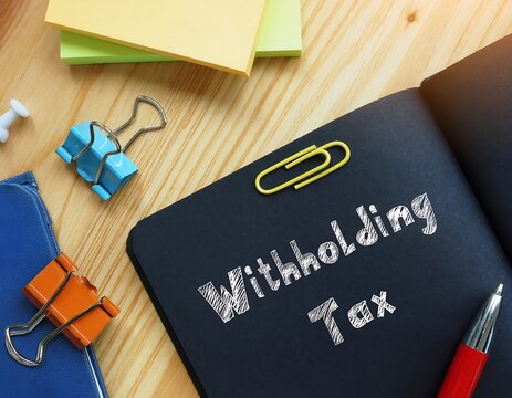 Withholding Tax Concept on a Black Notebook with Office Supplies.