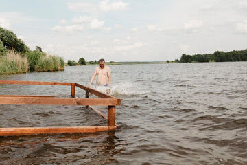 Fototapeta premium dynamic, relaxed shot boy jumping into natural lake. child is captured mid flight, creating sense excitement. image perfect family vacations, water safety, promoting active lifestyle among children