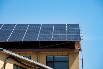 Obraz premium Solar Panels Installed on Residential Building Roof Under Clear Blue Sky