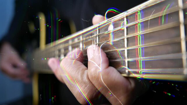 Close up of fingers playing guitar strings