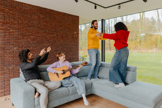 Friends enjoying music and dancing together at home