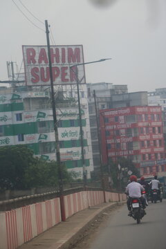  Dhaka, Bangladesh - June 14, 2026:Roadside sign for rahim super market viewed from a motorcycle with roadside billboard supermarket buildings motorcycle