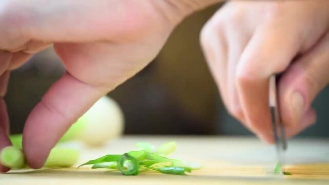Hands of a cook skillfully chopping organic greens and preparing fresh ingredients for a healthy recipe.
