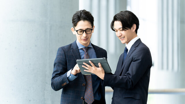 タブレットを確認する2人の男性ビジネスマン, Two Businessmen Reviewing a Tablet