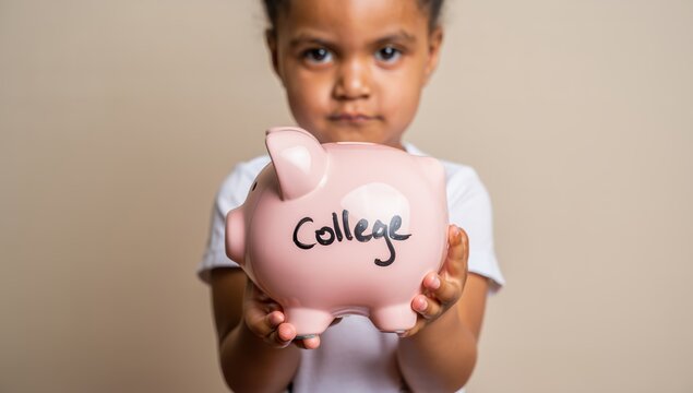 A young African American girl holds a pink piggy bank labeled College, gazing forward with a determined expression, symbolizing future education savings and financial planning for children.