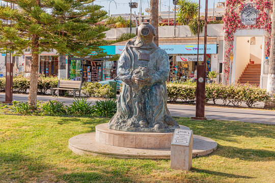 12 May 2026, Bodrum, Turkiye: Bronze statue of a traditional sponge diver in a vintage diving suit, holding a sponge, standing on a green lawn