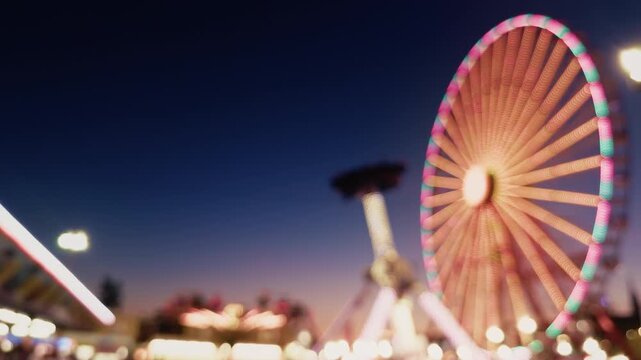 Blurred Carnival Lights With Colorful Bokeh At Amusement Park At Night