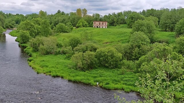 Pastoral river valley with a house on the hill and lush trees, countryside serenity, rural lifestyle, slow travel, mindfulness.