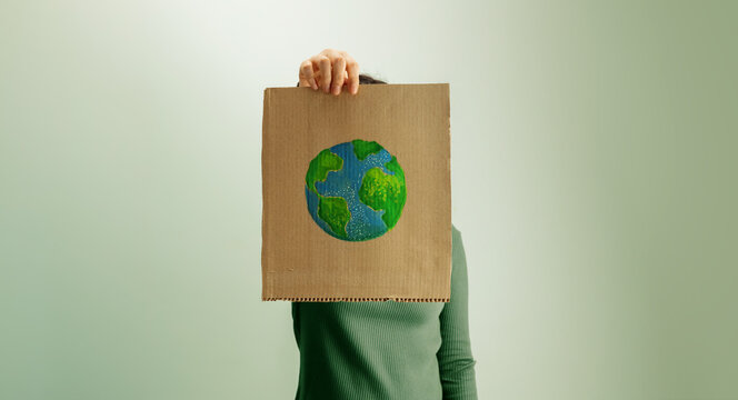 arth Day expression with person holding cardboard sign and hand painted globe, environmental awareness