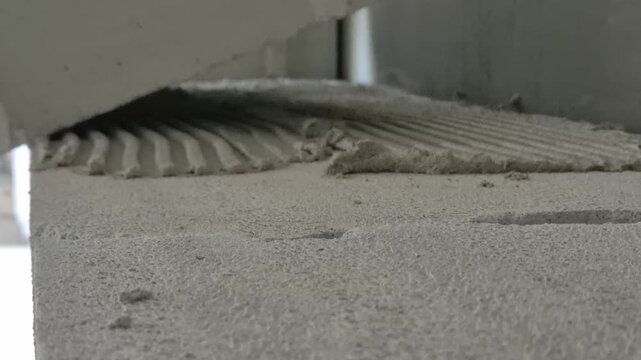 Placing another aerated concrete block onto the prepared mortar bed during interior wall construction, close up normal speed footage