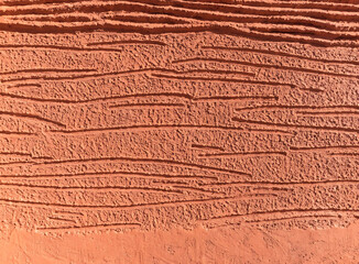 Fototapeta premium Textured terracotta wall background with horizontal linear pattern