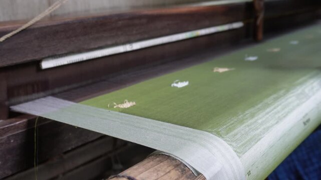artisan weaving fabric on traditional handloom