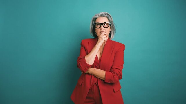 Pensive senior businesswoman in a red suit having a eureka moment. A creative female entrepreneur solving a problem and feeling confident