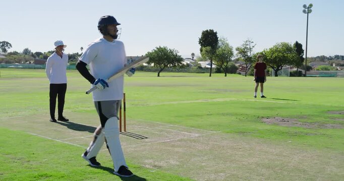 Male batsman stepping into crease swinging bat to hit ball, walking off after bowler's run-up