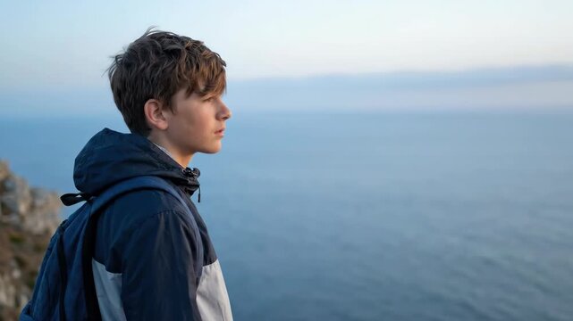 Teenager profile backpack on cliff by calm sea horizon, young coastal travel adventure scene at dusk with side view jacket and sky