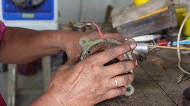 Technician repairing copper motor windings with precision
