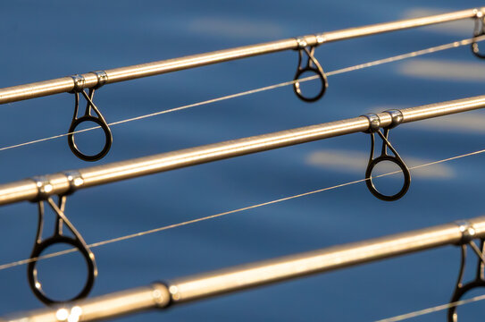 Fishing rods placed on a stand, rod bridge. Close-up of the rings of some carp rods