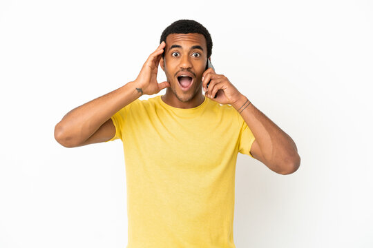 African American handsome man using mobile phone over isolated white background with surprise and shocked facial expression