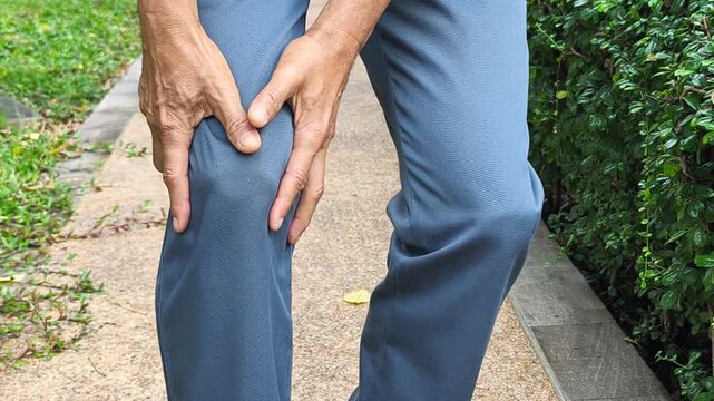 Hand of middle aged old man holding knee joint pain, concept of osteoporosis, thin bone, osteoarthritis; gout, knee bone joint injury problem