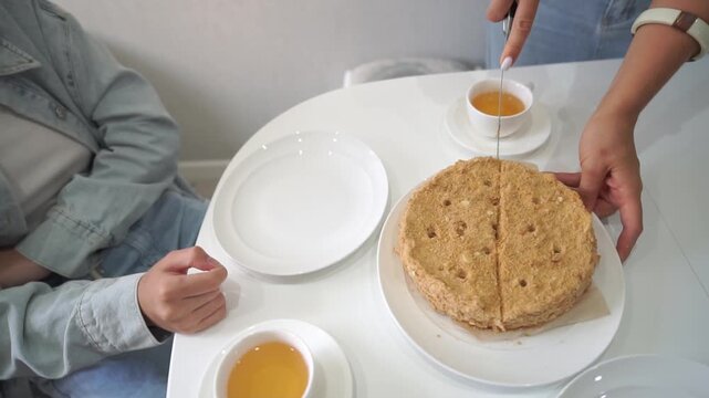 Cake, Tea, Cutting: Person cutting cake on white table for tea time.