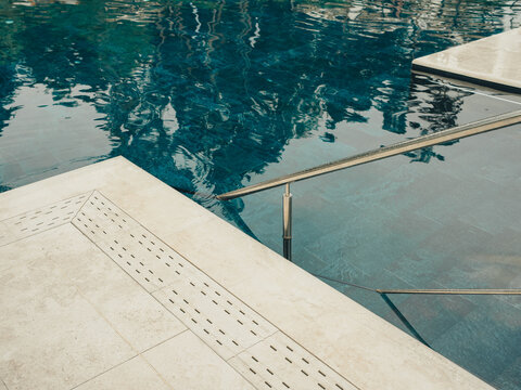 element of a swimming pool with blue water and a front with a ladder