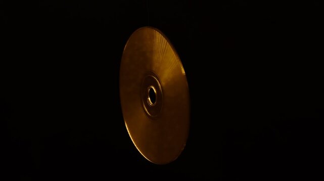 Rainbow light reflecting of a surface of a rotating CD-DVD disk against a dark background, highlight their reflective surfaces in different ways