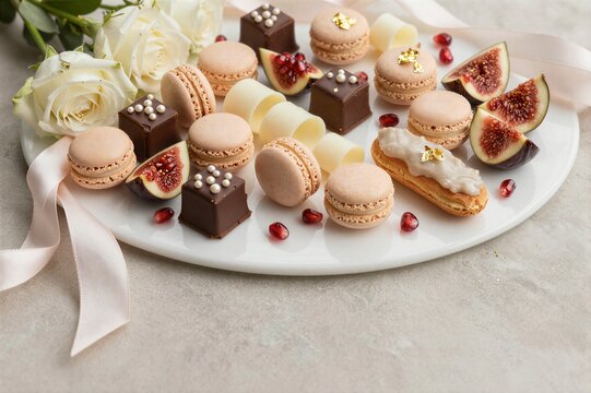 Assorted macarons and chocolates arranged on serving platter