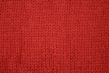 Fototapeta premium Close-up top view of red wool knitted texture background