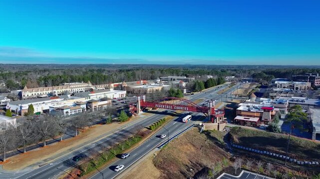 Wide shot of The Peachtree Corners pedestrian bridge, The Forum Peachtree Corners shopping mall, Peachtree Parkway (SR 141) in Georgia, drone shot