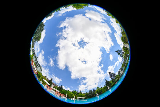 Partly cloudy sky from taken from the bottom of a swimming pool with circular fisheye lens    