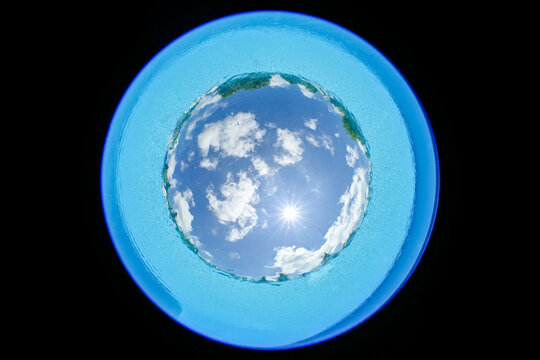 Partly cloudy sky from taken from the bottom of a swimming pool with circular fisheye lens    