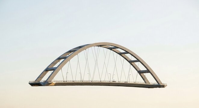 Modern arch suspension bridge structure with steel elements and a clear sky background