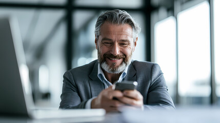 Fototapeta premium Smiling businessman using mobile phone for business communication